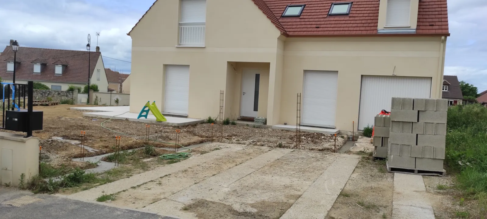 Chantier de maçonnerie à Plailly — ferraillage des piliers et parpaings avant montage du muret